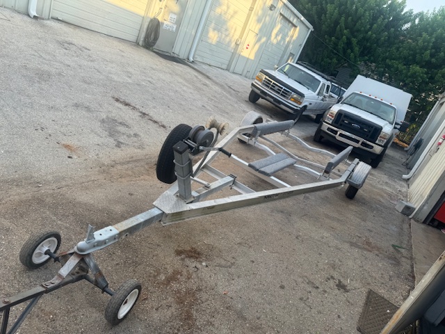 Rebuilt aluminum boat trailer with new bunks and tires sitting outside the Clearwater shop.